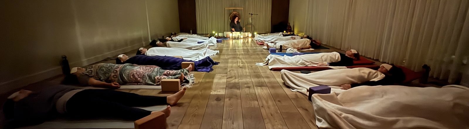 A group resting together during a candlelit sound journey